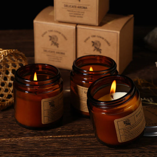 Aromatherapy candle in a brown glass cup on a bedside table