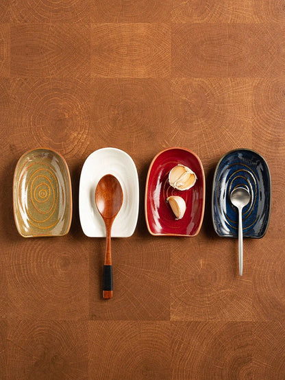 Vintage style ceramic cutlery holder with spoons and spatulas on a kitchen counter