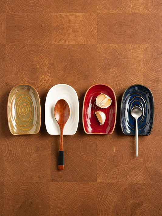 Vintage style ceramic cutlery holder with spoons and spatulas on a kitchen counter