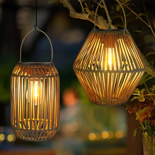 Woven solar lantern hanging from a branch over a patio table in the evening