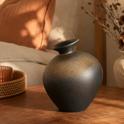 Black terracotta style ceramic vase with stone-like glaze on a shelf