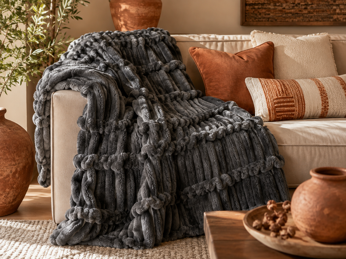 Soft fluffy striped throw blanket folded on a bed