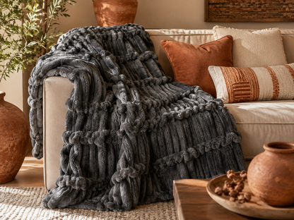 Soft fluffy striped throw blanket folded on a bed