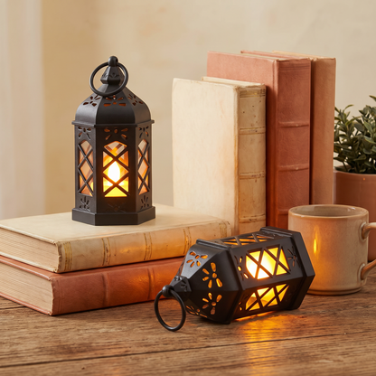 Small retro portable lamp glowing on a wooden desk beside books