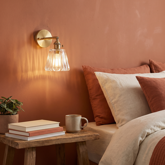 White Nordic brass and glass wall lamp mounted above a bedside table