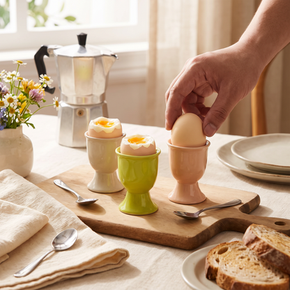 Colorful ceramic egg cup holders set on a breakfast table