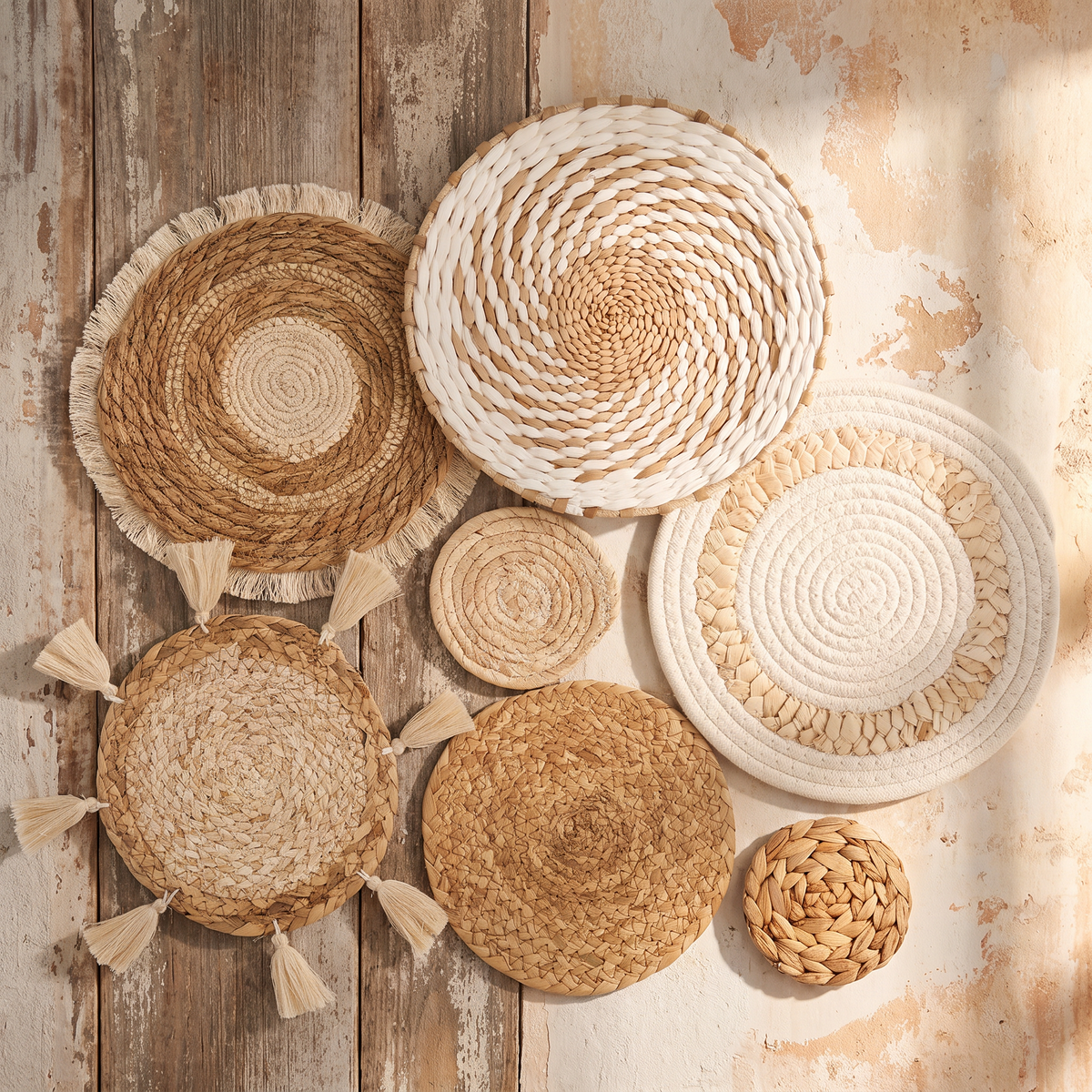 Seven woven wall baskets arranged as a gallery on a bedroom wall above the bed